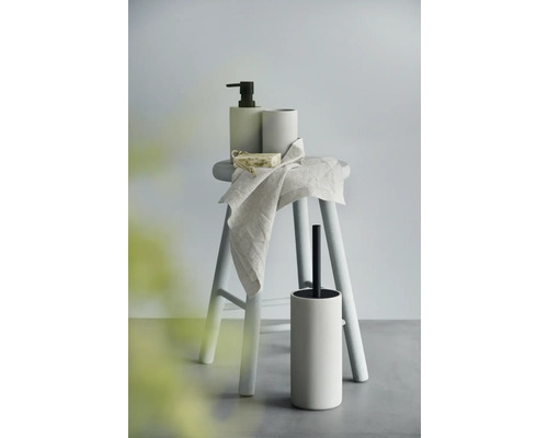 Koupelnové doplňky na stoličce: dávkovač mýdla, kelímek, mýdlo, ručník a WC štětka