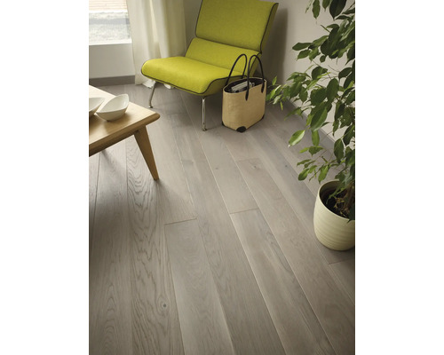 Světlý obývací pokoj s dřevěnou podlahou, křeslem a pokojovou rostlinou