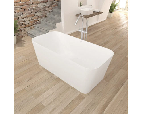 Volně stojící vana v koupelně s dřevěnou podlahou a umyvadlem