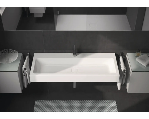 Moderní koupelna s obdélníkovým umyvadlem, armaturami a úložnými prostory.