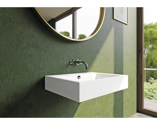 Moderní koupelna s umyvadlem, baterií a kulatým zrcadlem