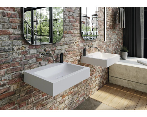 Koupelna se dvěma bílými umyvadly na desku na cihlové zdi se zrcadly