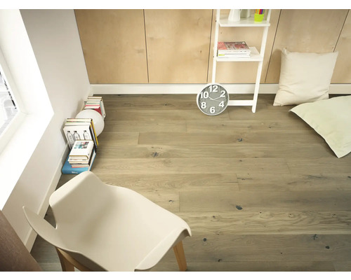 Světlý pokoj s dřevěnou podlahou, policovým žebříkem, hodinami, polštáři a židlí.