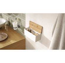 Koupelnová scéna s umyvadlem, držákem na kelímek na zubní kartáčky a nástěnnou policí s bambusovým víkem pro uložení koupelnových potřeb.