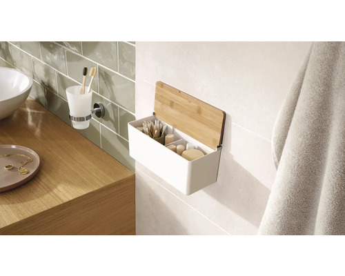 Koupelnová scéna s umyvadlem, držákem na kelímek na zubní kartáčky a nástěnnou policí s bambusovým víkem pro uložení koupelnových potřeb.