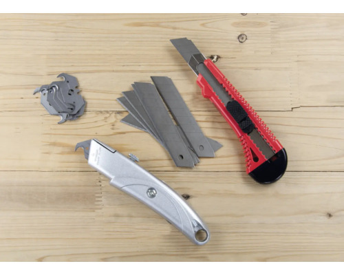 Dva nože a čepele na dřevěném pozadí