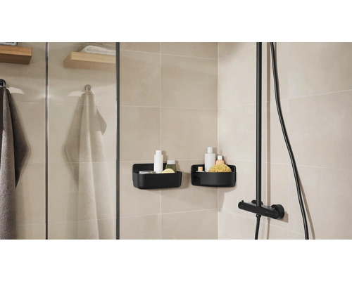 Koupelna se sprchou, ručníky a dvěma černými sprchovými košíky pro uložení koupelnových potřeb