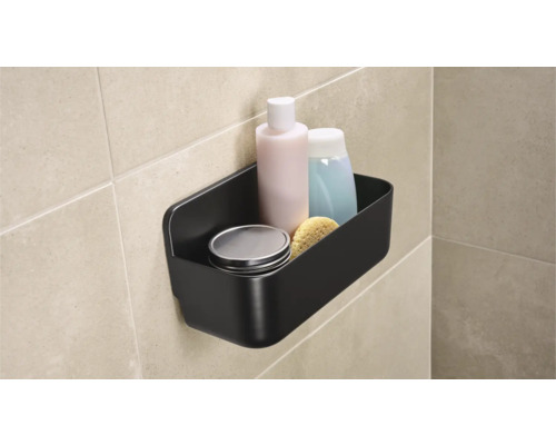 Černá koupelnová police s toaletními potřebami na stěně