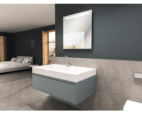 Koupelna s umyvadlem, zrcadlem a postelí