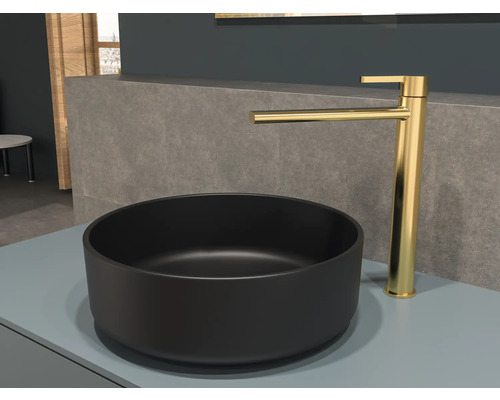 Černé umyvadlo na desku se zlatou baterií na polici