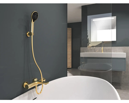 Koupelna se zlatou sprchovou baterií a umyvadlem