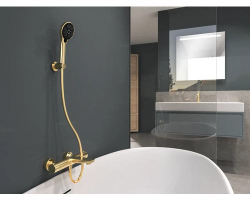 Koupelna s vanou, umyvadlem a zlatou sprchovou baterií.