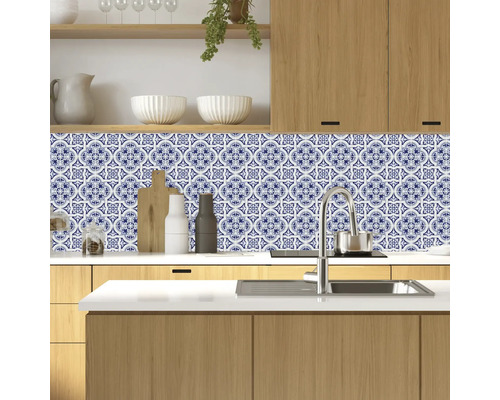 Kuchyňská scéna s modrobílými vzorovanými obkladovými nálepkami jako ochrana proti stříkající vodě
