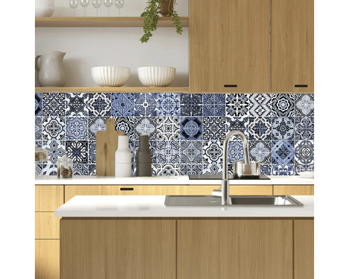 Kuchyňská scéna s modrými vzorovanými samolepkami na dlaždice jako ochrana proti stříkající vodě