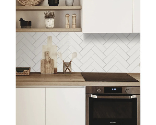 Kuchyňská scéna s bílými rybími dlaždicemi na zdi.