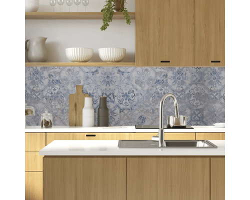 Kuchyňská scéna s dřevěnými skříněmi, dřezem a dekorativními obklady jako ochrana proti stříkající vodě