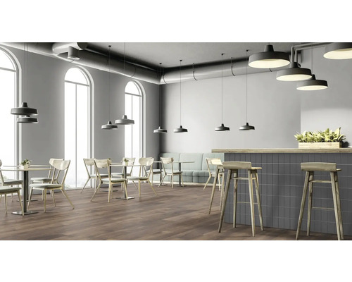 Interiér restaurace se stoly, židlemi, barem a závěsnými svítidly