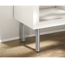 Detail bílého nábytku se stříbrnými nohami na dřevěné podlaze