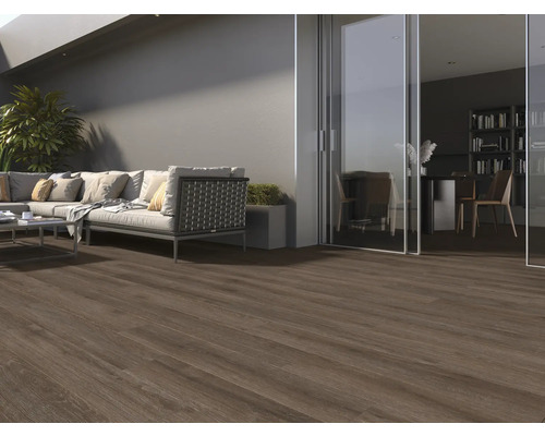 Terasa s tmavou dřevěnou podlahou, pohovkou a výhledem do místnosti s knihovnou