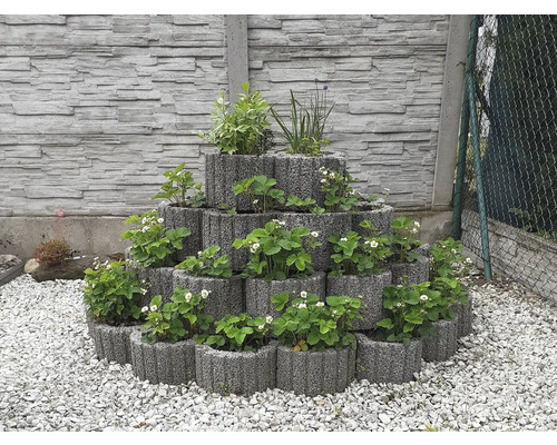 Několik osázených bylinkových záhonů z betonu tvoří v zahradě pyramidu.