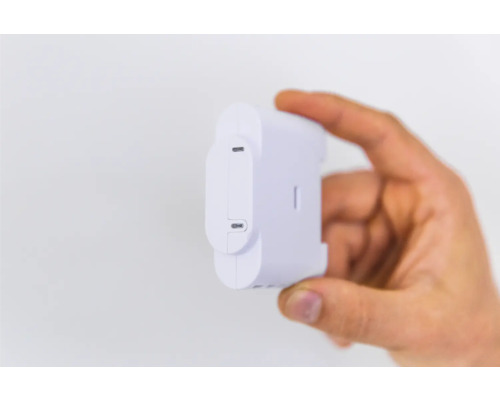 Ruka drží bílý snímač energie Shelly