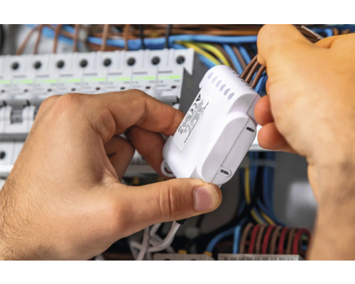 Elektrikář montuje rozdělovač do rozvaděče