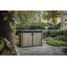 Zahradní skříň na nářadí s dřevěným efektem a žena v pozadí v zahradní krajině