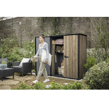 Zahradní scéna se ženou před zahradním domkem se zahradním nářadím a zahradním nábytkem