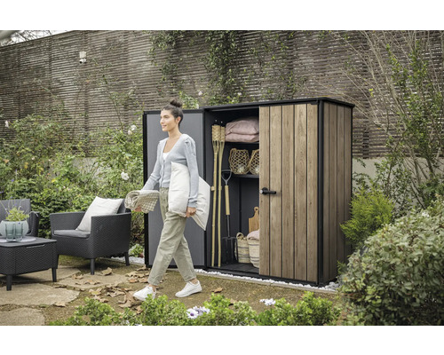 Zahradní scéna se ženou před zahradním domkem se zahradním nářadím a zahradním nábytkem