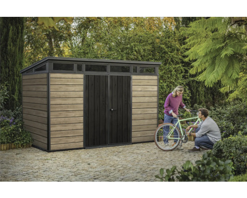 Zahradní skříň s pultovou střechou, dřevěnou stěnou a párem lidí s kolem na zahradě