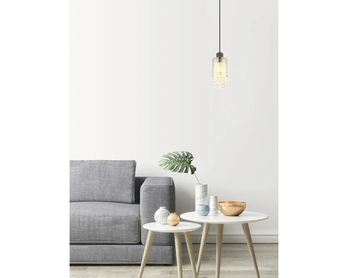 Světlý interiér s šedou pohovkou, bílými stolky a dekorativním závěsným svítidlem