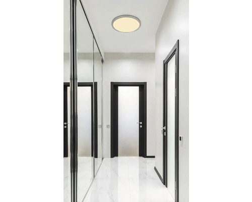 Světlá chodba s kulatým stropním svítidlem a zrcadlovou skříní s posuvnými dveřmi.