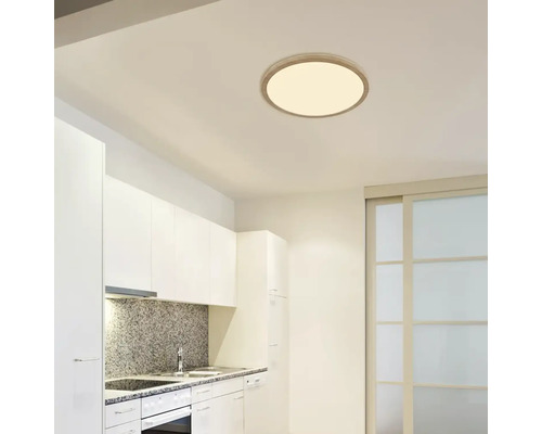 Moderní kuchyně s kulatým stropním svítidlem pro světlé a přátelské prostředí.