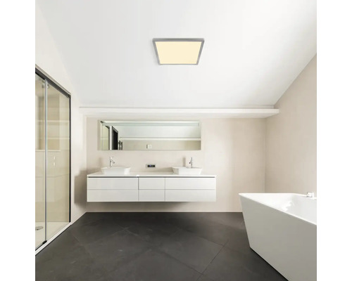 Moderní koupelna se čtvercovým stropním svítidlem, umyvadly a vanou