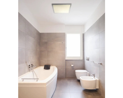 Světlá koupelna s vanou, toaletou, bidetem a čtvercovým stropním svítidlem