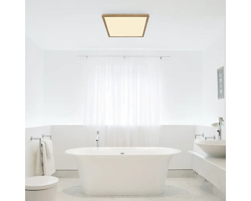 Moderní koupelna s volně stojící vanou a čtvercovým stropním svítidlem s dřevěným rámem