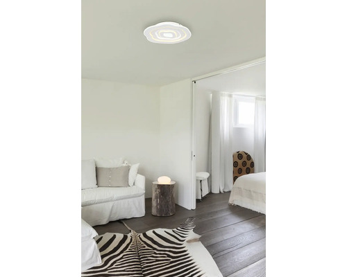 Světlý obývací pokoj s moderním stropním svítidlem, pohovkou a zebřím kobercem