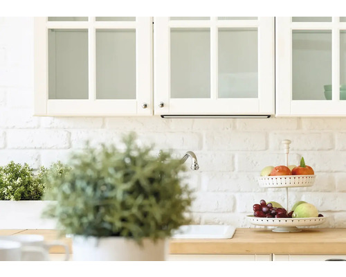 Kuchyňská scéna se závěsnými skříňkami, dřezem a dekorativním etažérem na ovoce