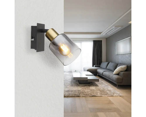 Nástěnné svítidlo z kovu a skla v obývacím pokoji.