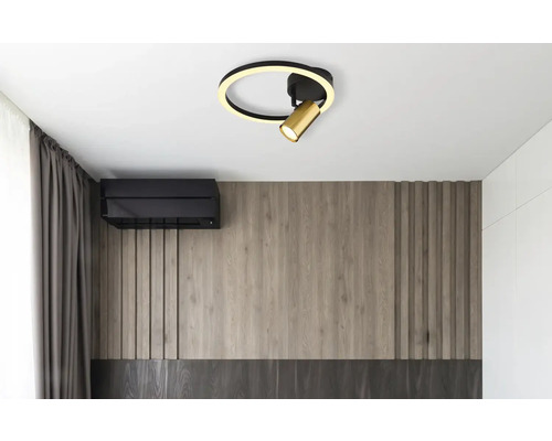 Stropní svítidlo s kruhovým designem a nastavitelným bodovým světlem v moderním pokoji.