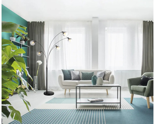 Obývací pokoj s pohovkou, křeslem, kobercem, stolem a obloukovou lampou