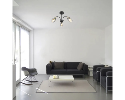 Obývací pokoj se stropním svítidlem se třemi rameny a skleněnými stínidly nad černou sedací soupravou