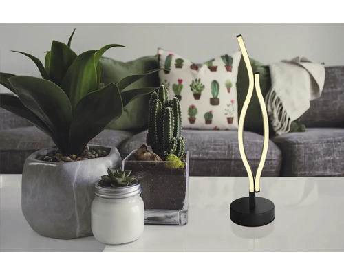 Dekorativní LED stolní lampa na stole s pokojovými rostlinami a pohovkou