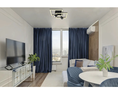 Obývací pokoj s televizí, pohovkou, jídelním stolem a stropním svítidlem