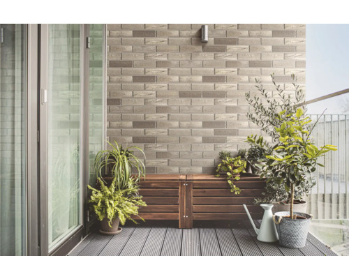 Balkon s kamennou stěnou, dřevěnou podlahou a rostlinami