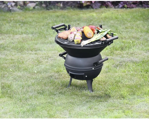 Kulatý gril s grilovaným jídlem na trávníku