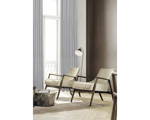 Obývací pokoj se dvěma křesly, stojací lampou a závěsy