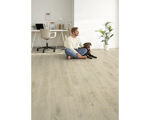 Světlá místnost s laminátovou podlahou, sedí na ní muž a pes, v pozadí stůl a kytara