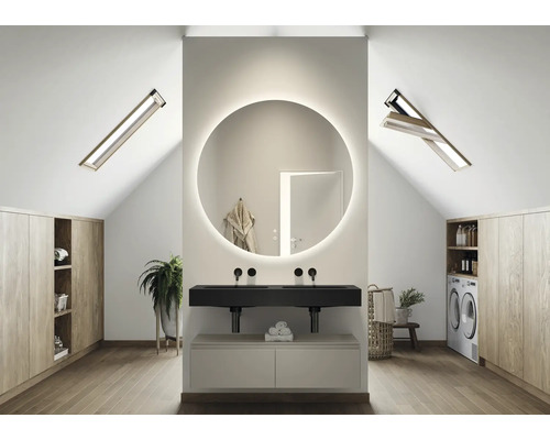 Světlá koupelna v podkroví s kulatým zrcadlem s osvětlením, umyvadlem, střešními okny a vestavěnými skříněmi