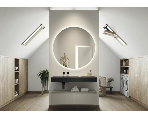 Moderní koupelna v podkroví s kulatým zrcadlem, umyvadlem a střešními okny.